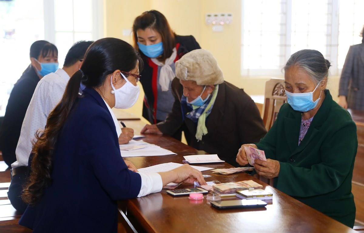 People affected by COVID-19 receive cash grant under the financial assistance package from the Government in 2020. (Illustrative photo: VietnamPlus)
