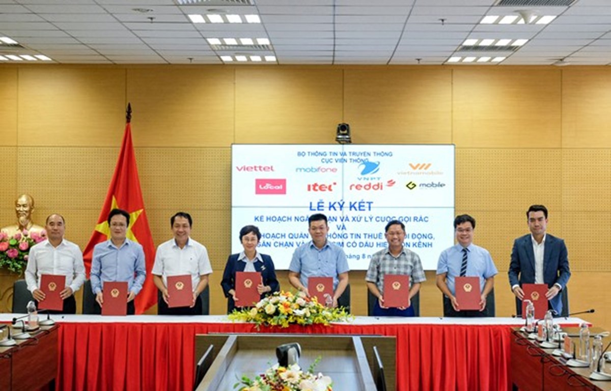 Representatives of Vietnamese mobile network operators – Viettel, VNPT, MobiFone, Vietnammobile, Local, Reddi, Itel, and GMobile – sign an agreement to fight spam calls jointly. (Photo: VietnamPlus)