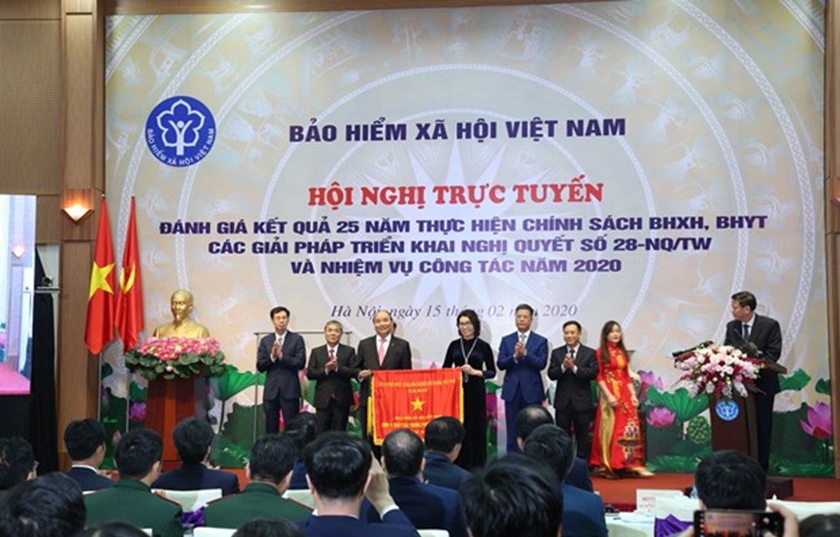 Prime Minister Nguyen Xuan Phuc presents emulation flag tothe Vietnam Social Security with the Government. (Photo: VietnamPlus)