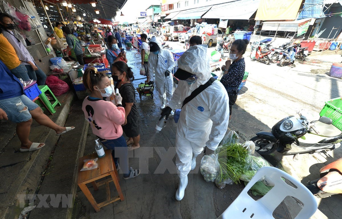 Staff spray disinfectant in a market in Samut Sakhon province, Thailand, December 21, 2020. (Photo: Xinhua/VNA)