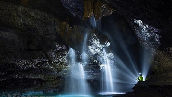Exploring waterfall in million-year-old cave