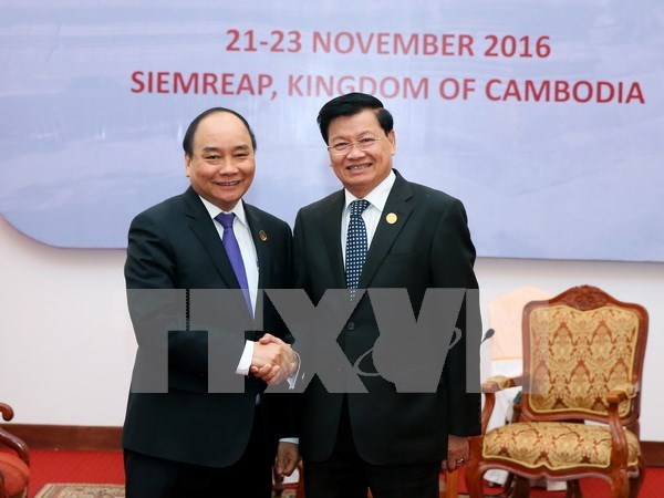 Prime Minister meets Lao counterpart hinh anh 1