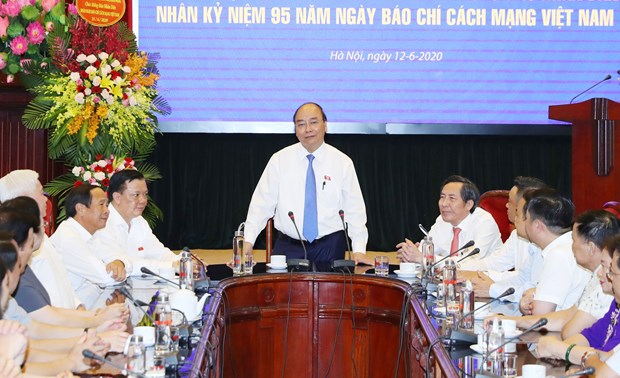 PM visits Nhan dan newspaper ahead of Revolutionary Press Day hinh anh 1