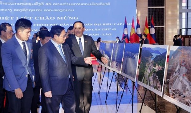 PMs of Vietnam, Laos visit photo exhibition on achievements of economic ties hinh anh 1